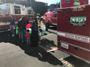 CERT volunteers show visitors how HAM Radio is used for communications.  Fire truck and CERT trailer visible in photo. 