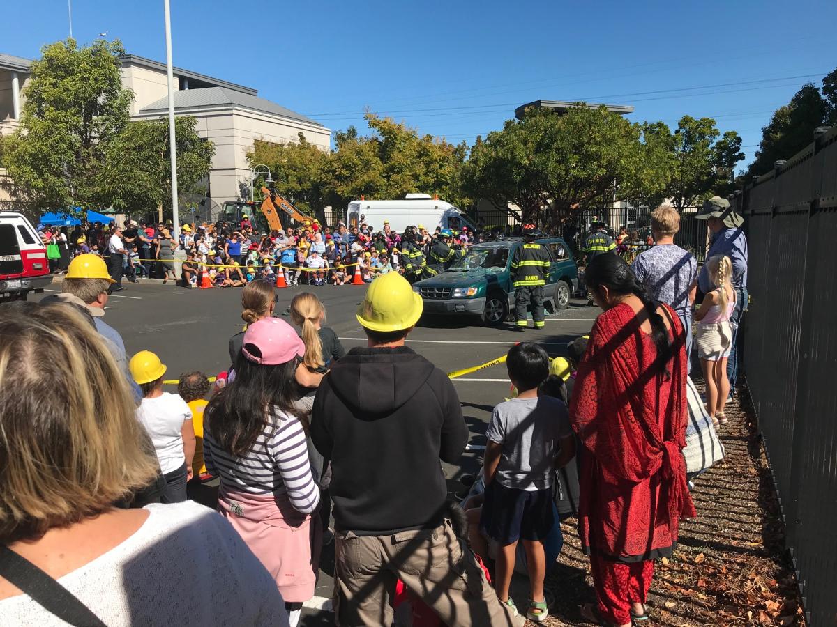 Crowd watches SMCFD firefighters demonstrate using the "jaws of life" to rescue a trapped victim
